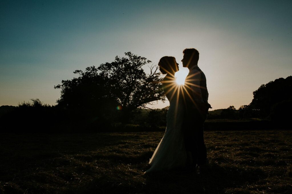bride and groom silhouette portrait with the sun setting in the background