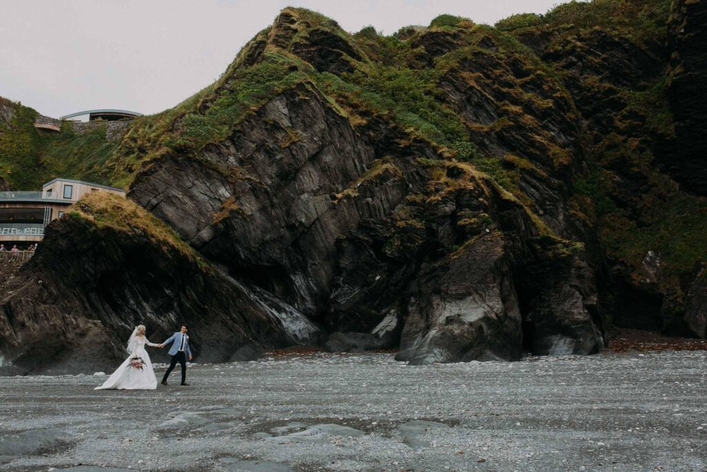 bride and groom walking on the beach in Ilfracombe