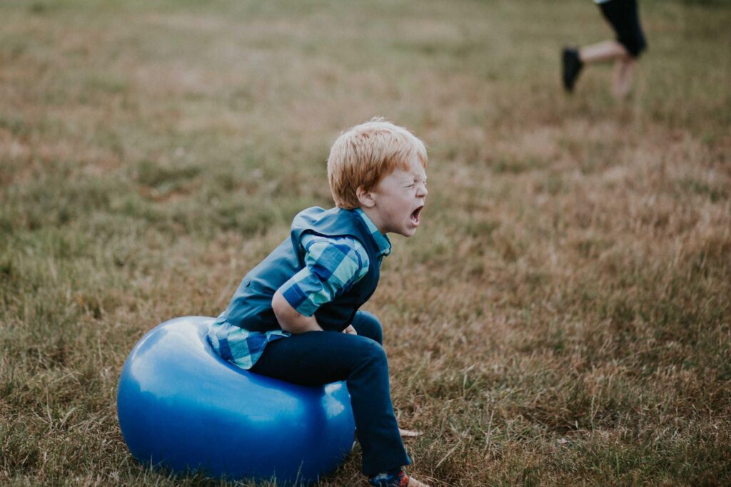 a boy is wildly jumping on a bouncy ball