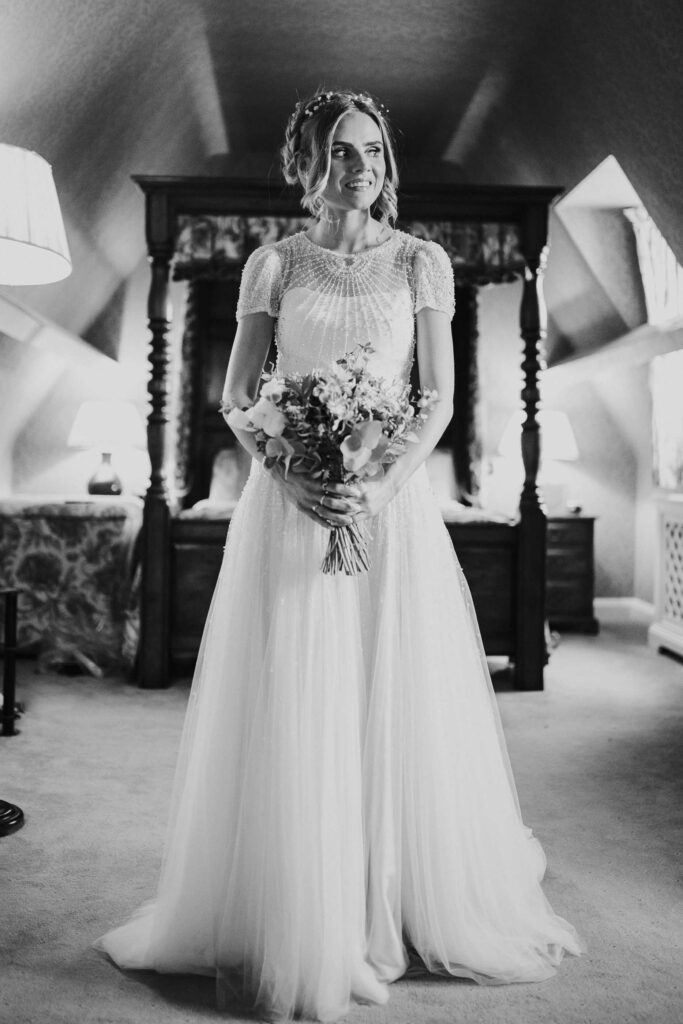 black and white full body image of a bride holding the flowers