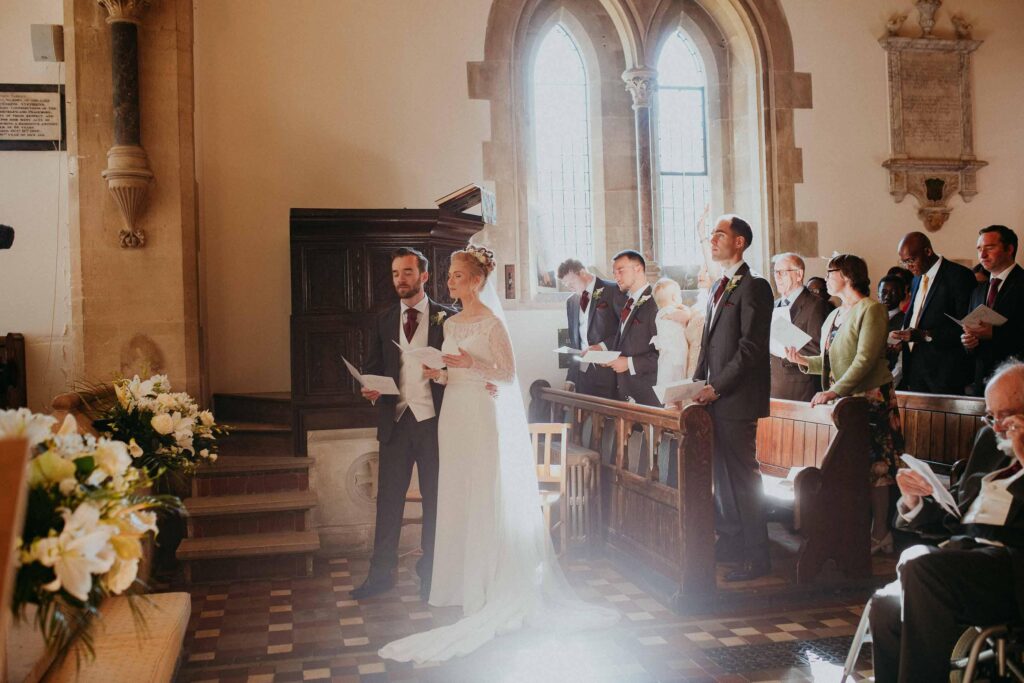 bride and groom deeply absorbed in the deep prayed sunlight softly lighting up brides veil