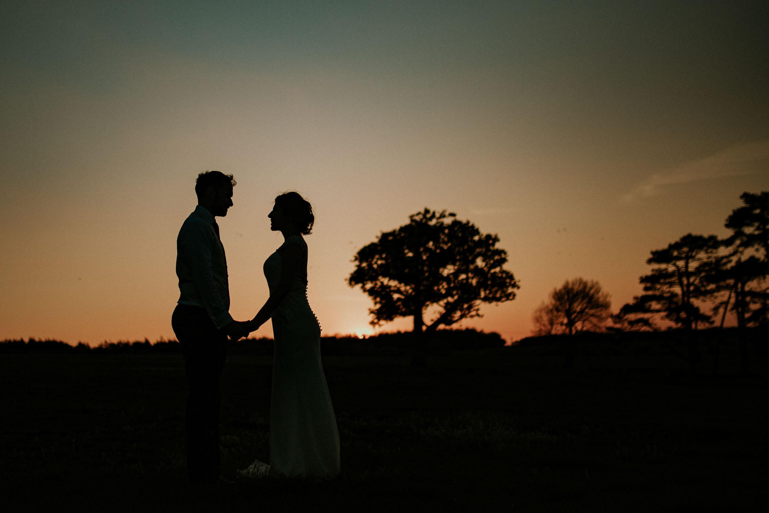 couple watching sunset silhouette