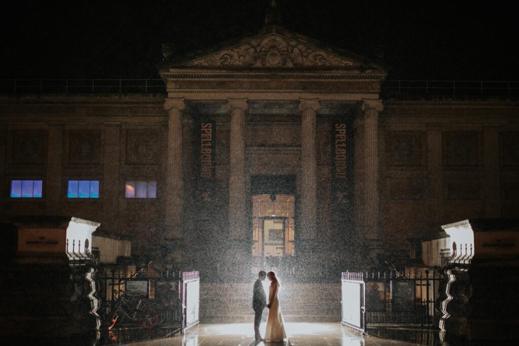 couple kissing in the rain on the front of ashmolean museum in oxford