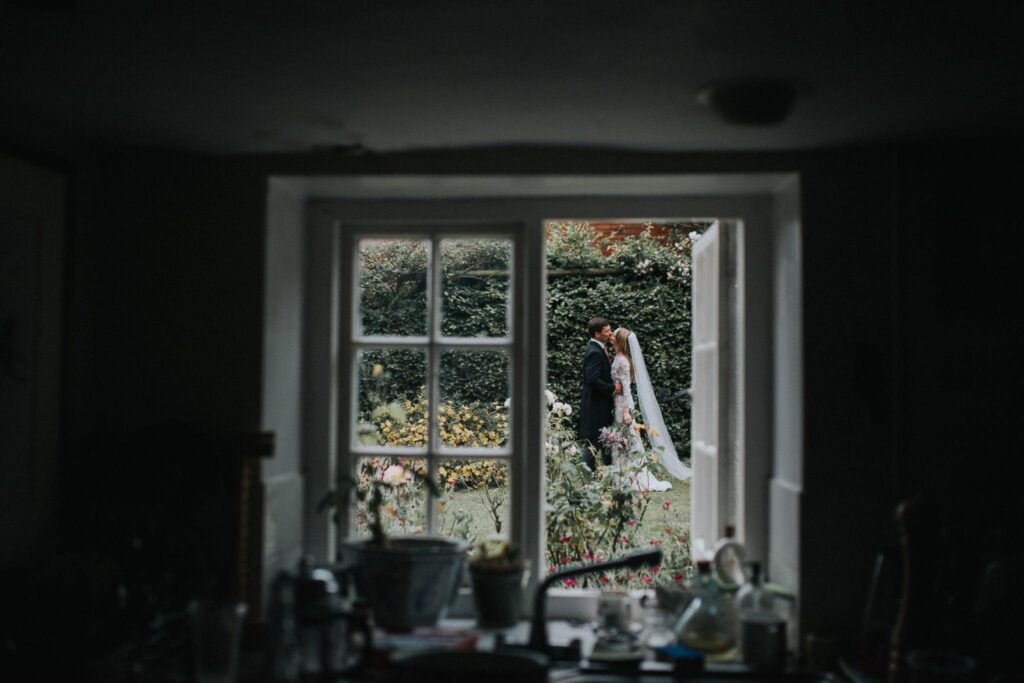 bride and groom kissing in on the boarstall tower grounds oxfordshire