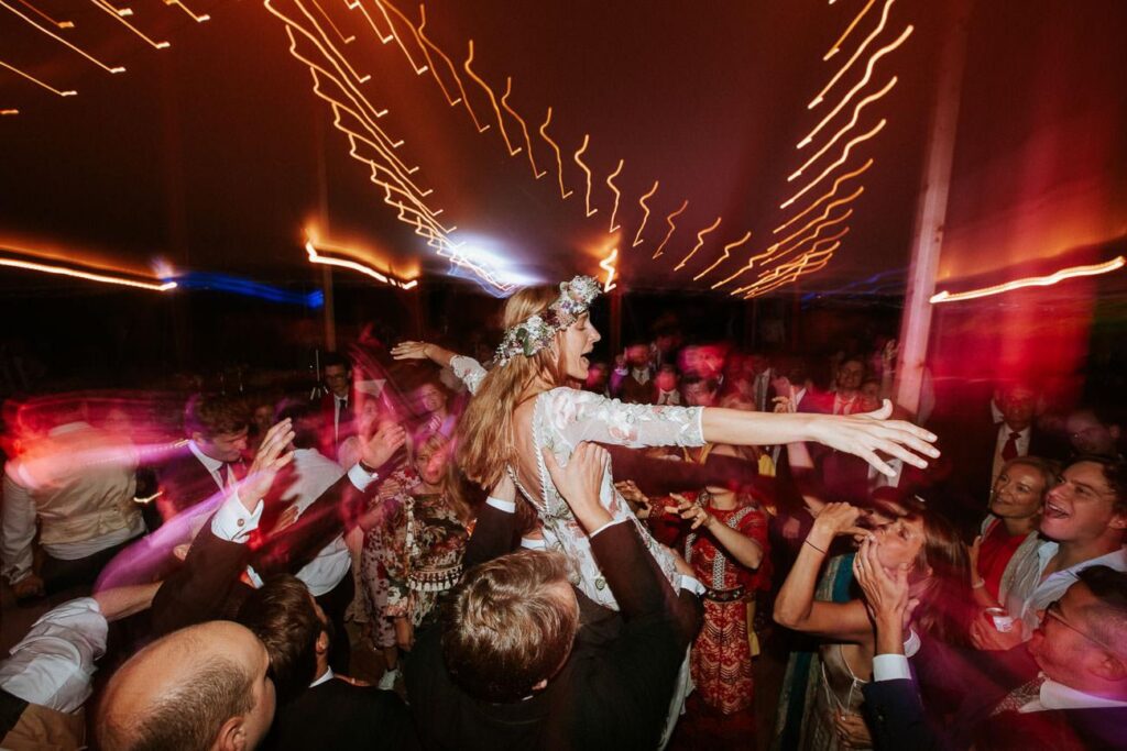 a bride crowd surfing on the dance floor