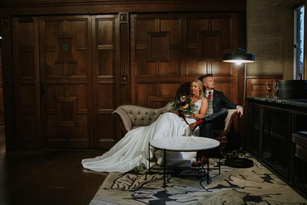 bride and groom sitting on the lounger in the Eynsham Hall