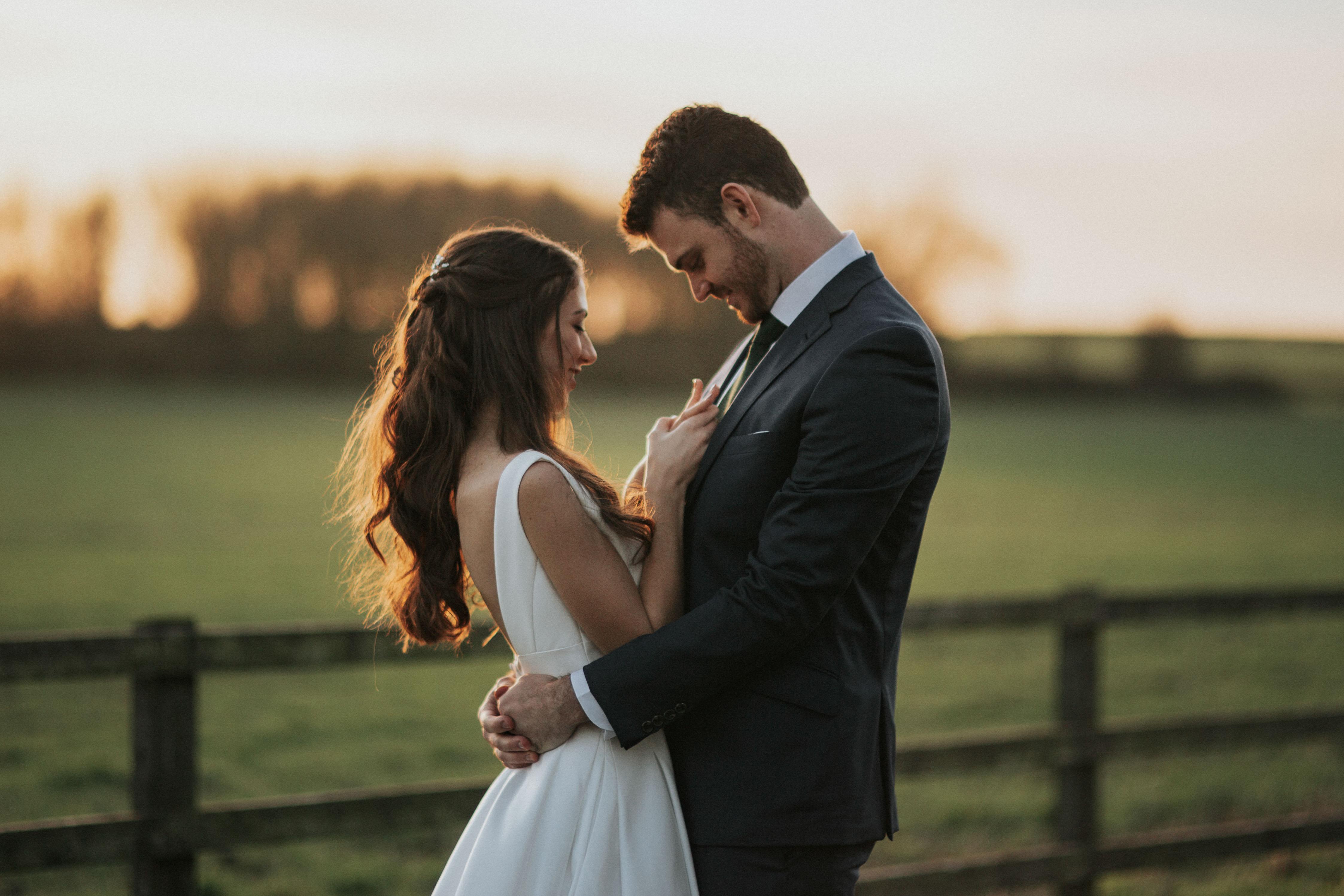 bride and groom cuddling on the fields in Stratton Audley, Oxfordshire