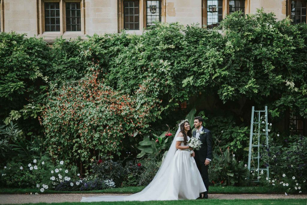 bride and groom walking in the garden of Bailliol College in Oxford