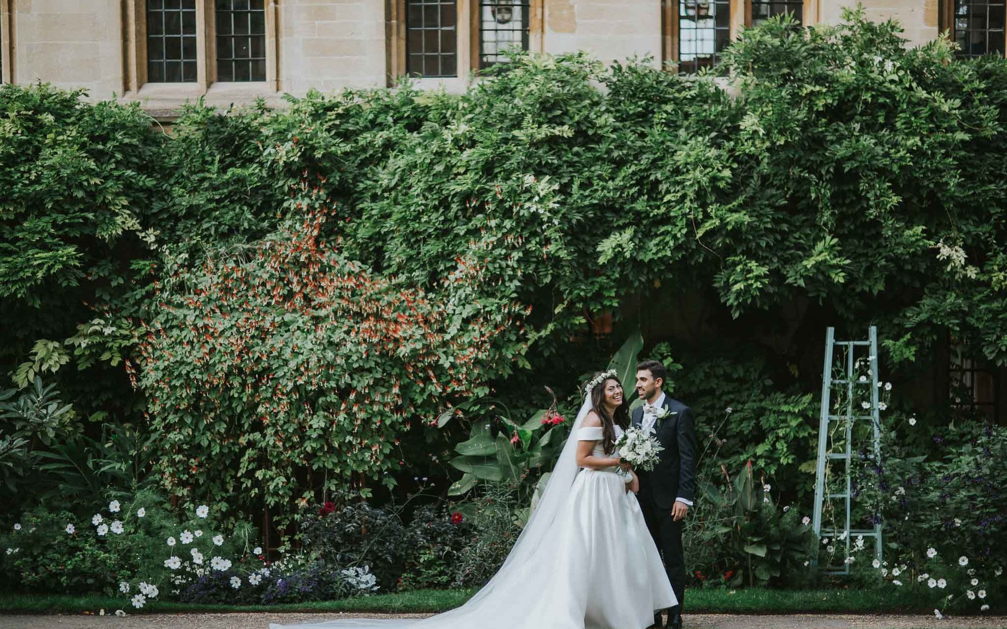 bride and groom walking in the garden of Bailliol College in Oxford