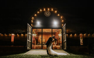 bride and groom kissing on the front of the lains barn